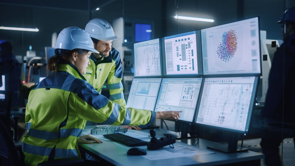 Two engineers looking at monitors